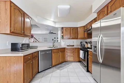 a kitchen with stainless steel appliances granite countertop a sink stove refrigerator and cabinets