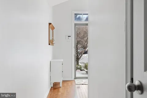 an entryway to room with wooden floor and windows