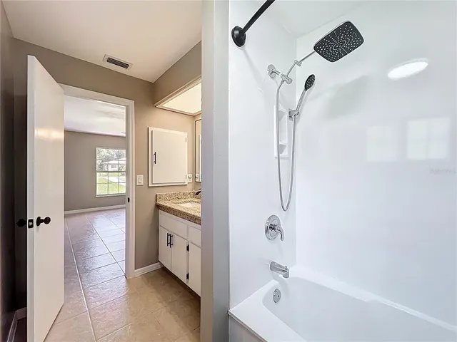 a bathroom with a tub sink and mirror