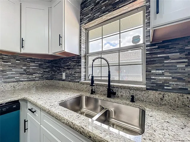 a kitchen with granite countertop a sink and a window