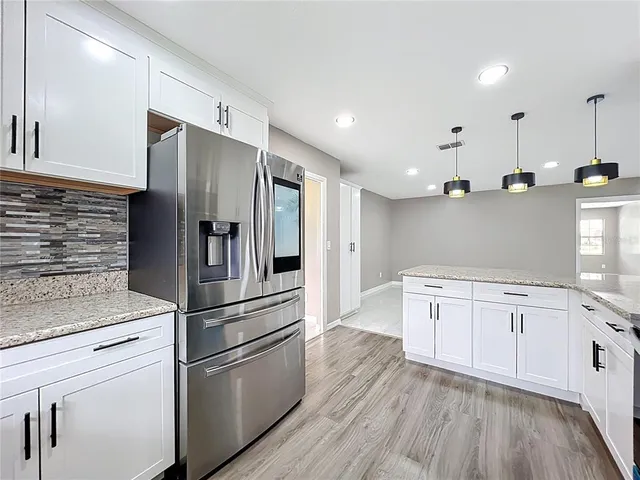 a kitchen with stainless steel appliances a refrigerator sink and cabinets
