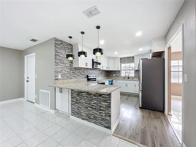 a kitchen with stainless steel appliances granite countertop a refrigerator sink and cabinets