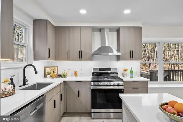 a kitchen with stainless steel appliances a stove a sink and a microwave