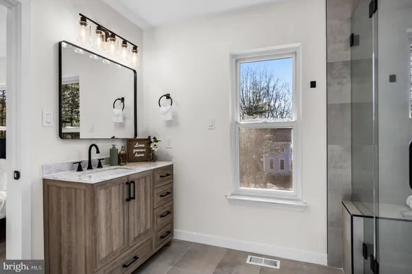 a bathroom with a sink a mirror and a window