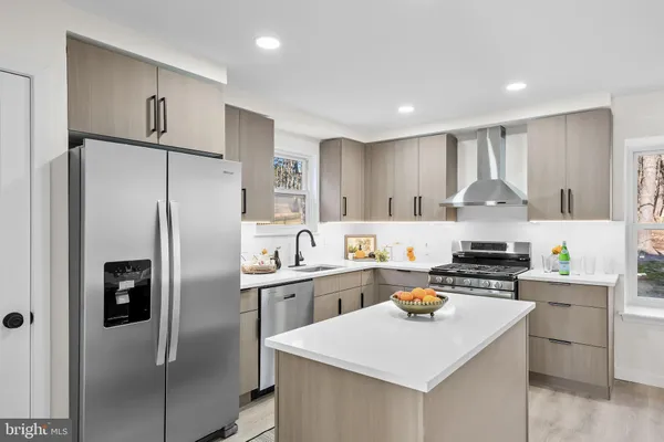 a kitchen with stainless steel appliances granite countertop a sink stove refrigerator and cabinets
