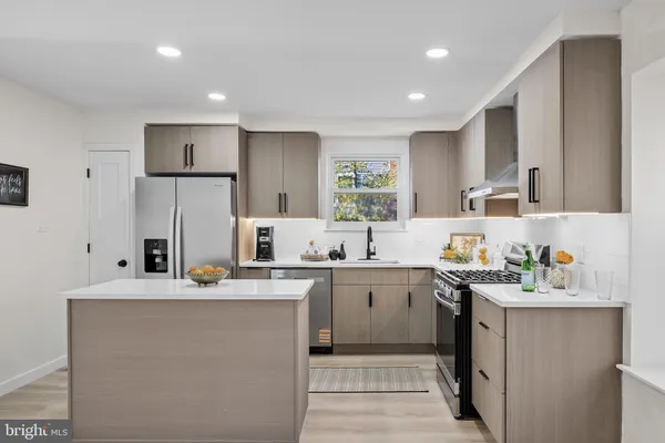 a kitchen with stainless steel appliances a sink stove and refrigerator
