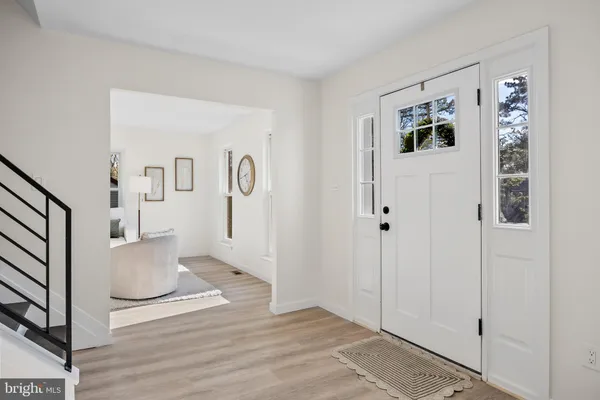 a view of a hallway with bathroom and wooden floor