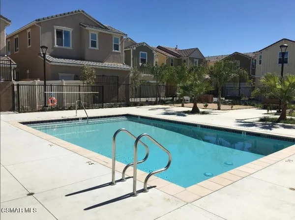 a view of a house with pool and chairs