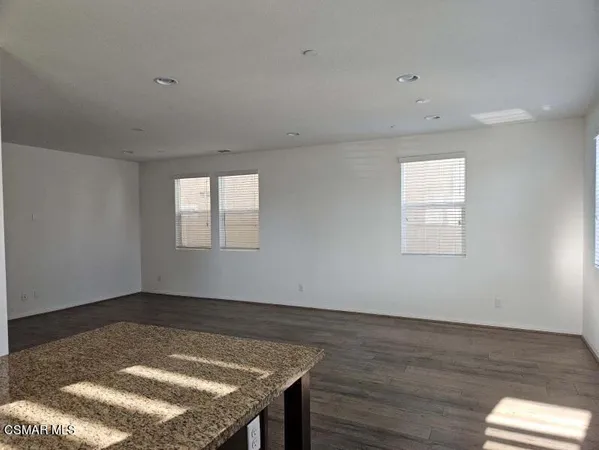 an empty room with wooden floor and window