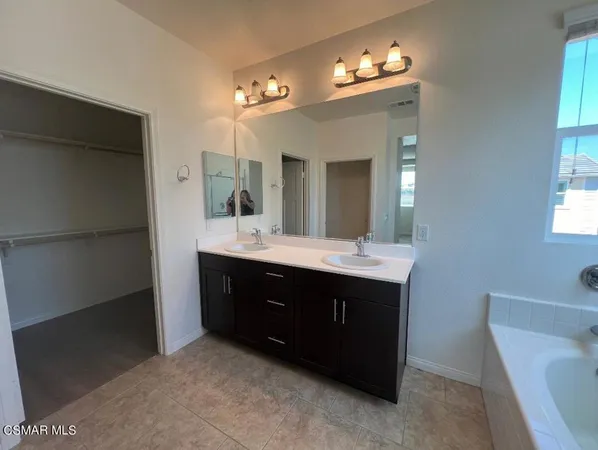 a spacious bathroom with a double vanity sink and a mirror