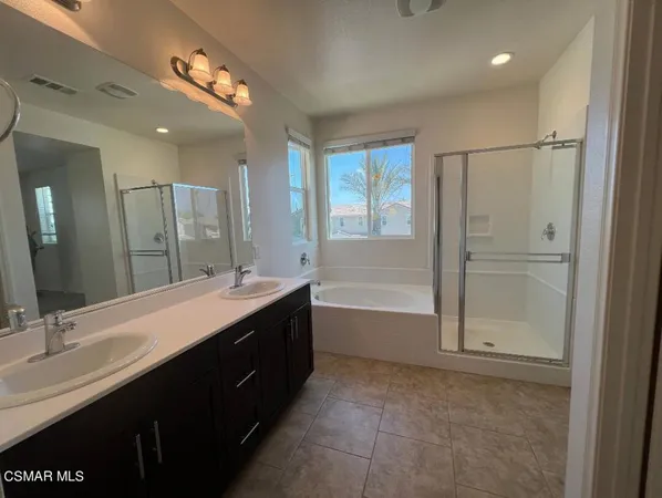 a bathroom with a tub sink vanity granite and mirror