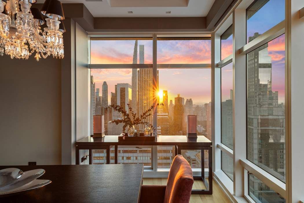 151 East 58th Street, Unit 35A Manhattan, NY 10022 - Photo 16 of 18 a view of a city from a living room filled with furniture