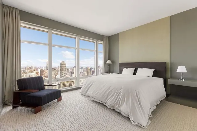a bedroom with a bed and a couch next to a window