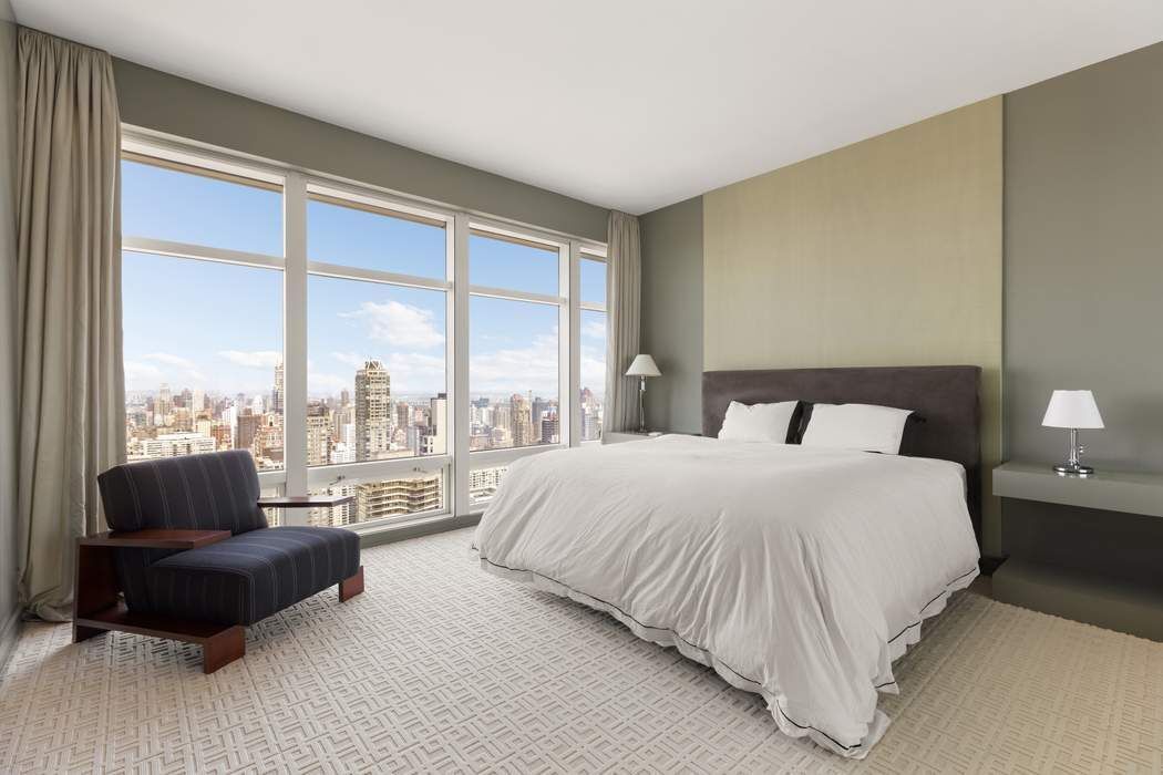 151 East 58th Street, Unit 35A Manhattan, NY 10022 - Photo 7 of 18 a bedroom with a bed and a couch next to a window