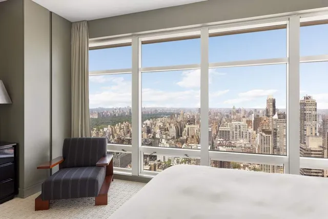 a bedroom with a large window and a bed