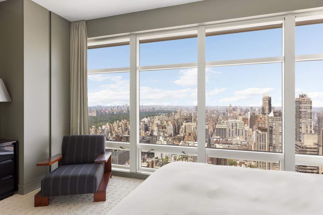 151 East 58th Street, Unit 35A Manhattan, NY 10022 - Photo 8 of 18 a bedroom with a large window and a bed