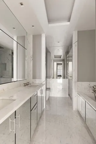 a large white bathroom with a granite countertop sink mirror and bathtub