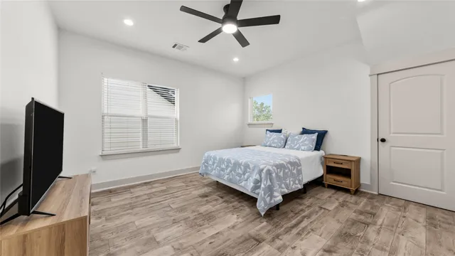 a bedroom with a bed tv and a window