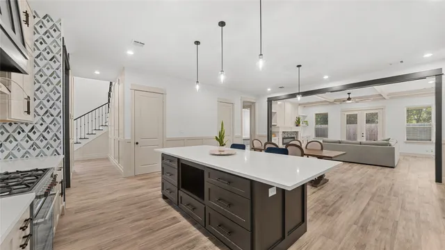 a kitchen with a sink stove and wooden floor