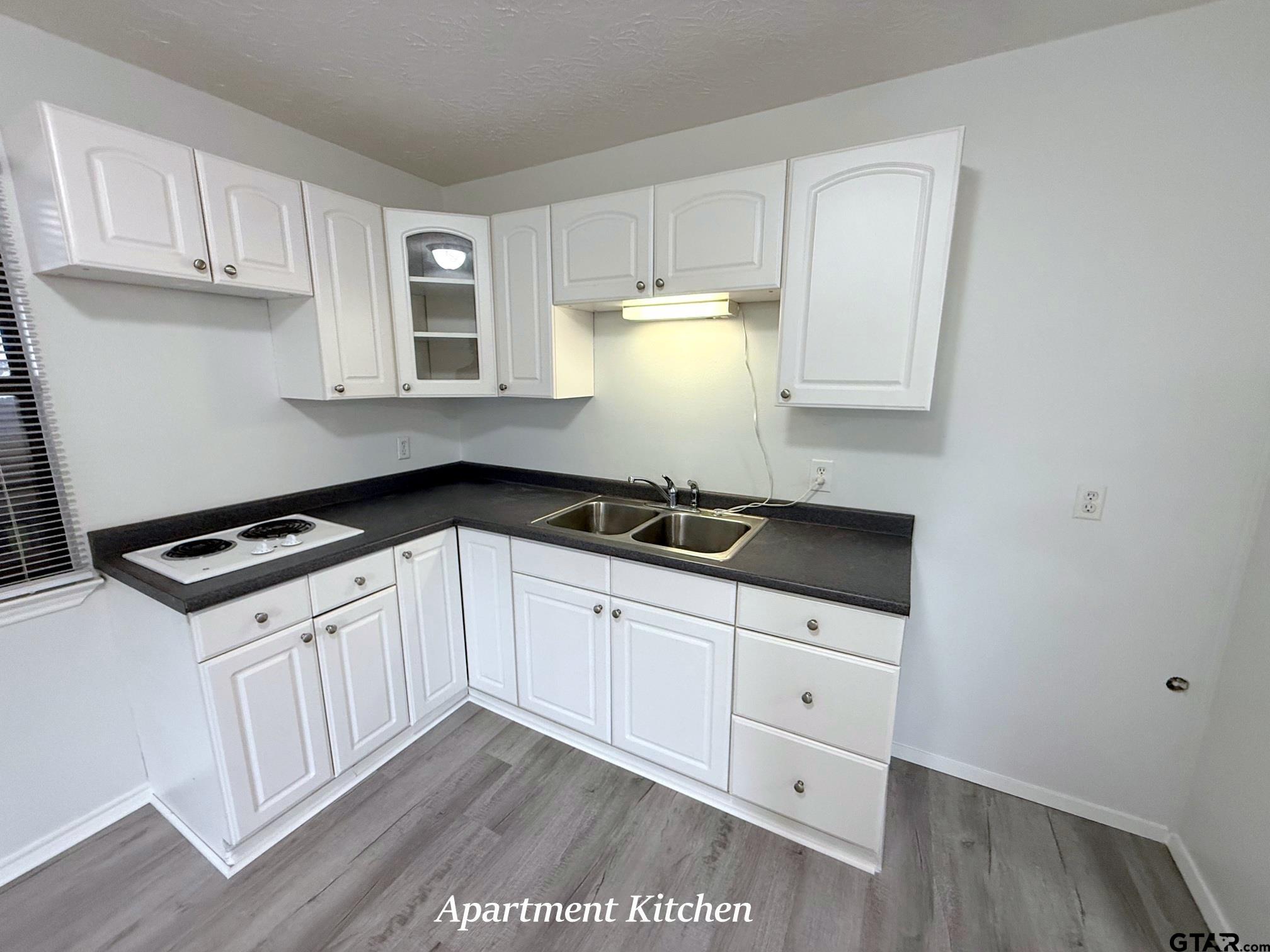 237 Oregon Street Van, TX 75790 - Photo 38 of 44 a kitchen with granite countertop white cabinets and black appliances