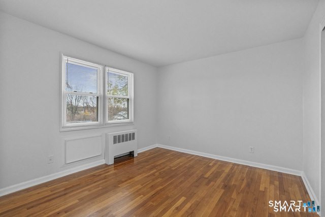146 Blachley Road, Unit C Stamford, CT 06902 - Photo 15 of 44 a view of an empty room with wooden floor and a window