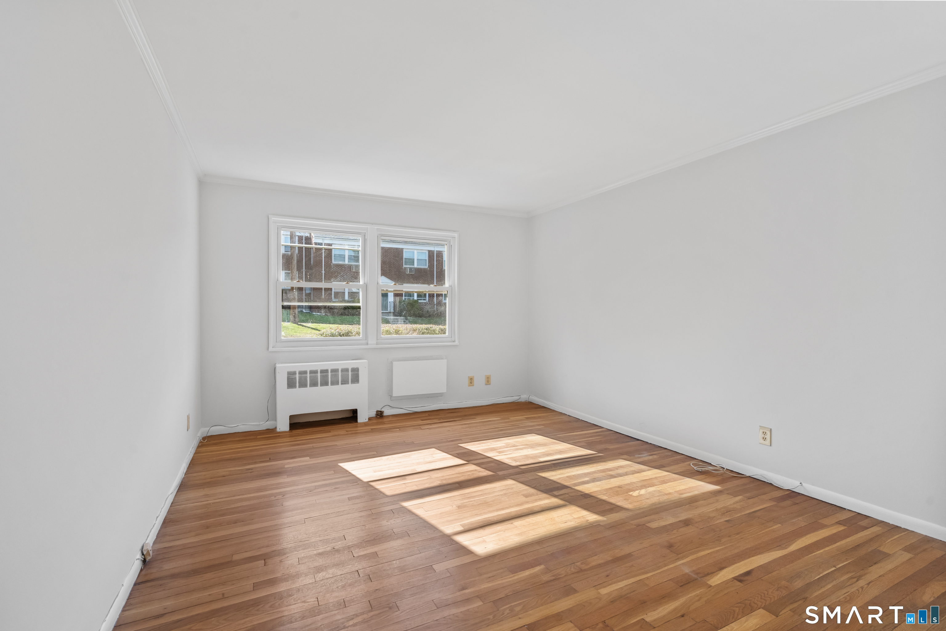 146 Blachley Road, Unit C Stamford, CT 06902 - Photo 18 of 44 a view of a room with wooden floor and white walls