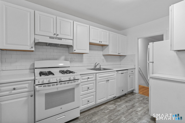 146 Blachley Road, Unit C Stamford, CT 06902 - Photo 9 of 44 a kitchen with granite countertop white cabinets and white appliances