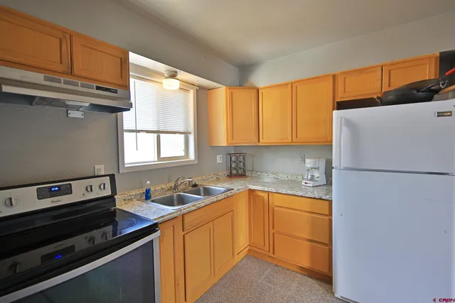 a kitchen with a refrigerator and a sink