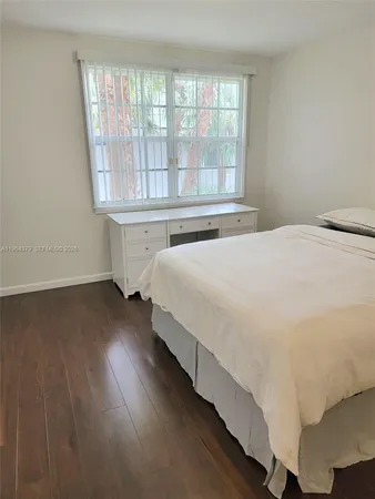 a large bed sitting in a bedroom next to a window