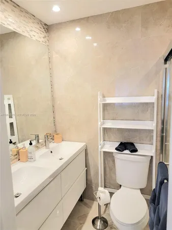 a bathroom with a sink a toilet and a mirror