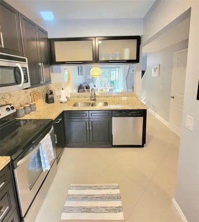 a kitchen with stainless steel appliances granite countertop a sink and a stove