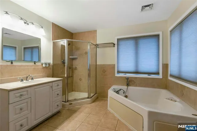 a bathroom with a tub sink and mirror