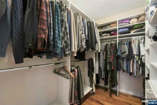 a view of walk in closet with clothes and shoes