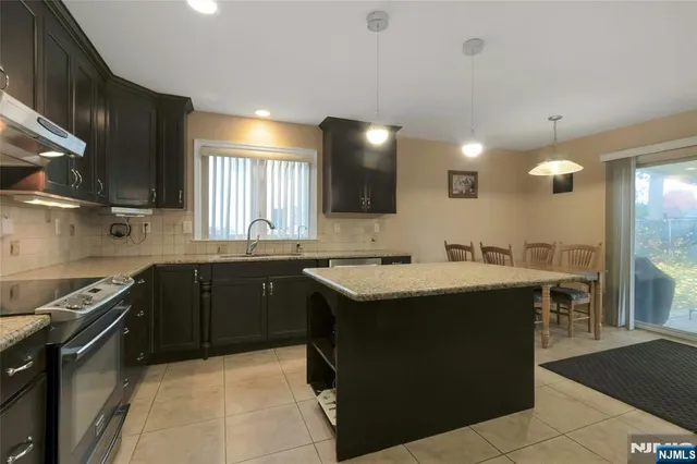a kitchen with a sink and a stove top oven with wooden floor