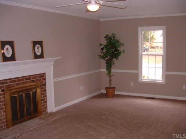 4641 Draper Road Raleigh, NC 27616 - Photo 4 of 9 an empty room with windows and fireplace