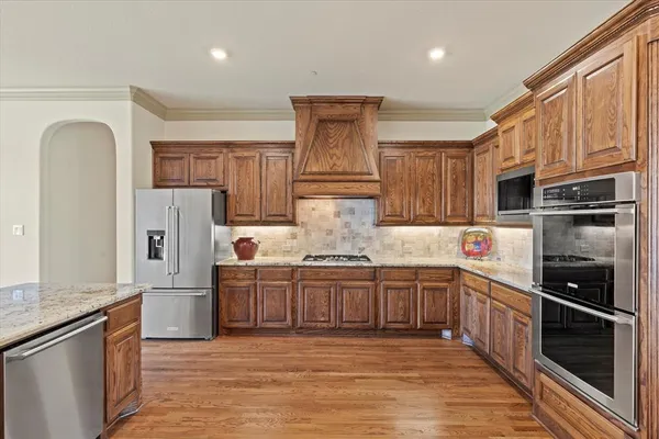 a kitchen with stainless steel appliances granite countertop a refrigerator and a stove top oven