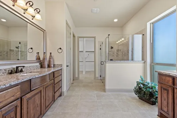 a bathroom with a granite countertop sink a mirror and a shower