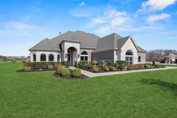 a front view of a house with a garden and plants