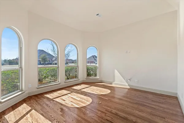 a view of a room that has wooden floor and large window