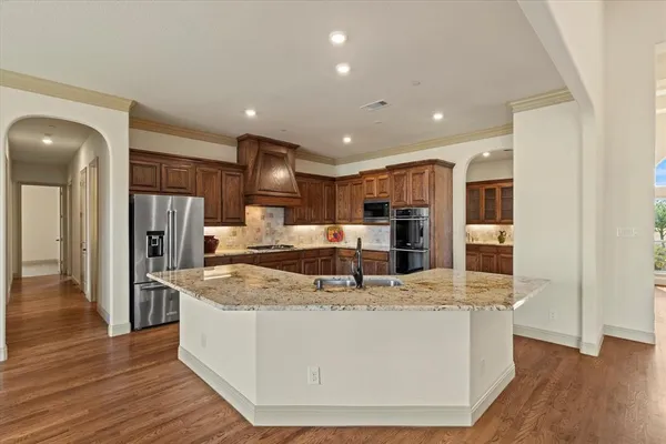a view of kitchen with stainless steel appliances granite countertop refrigerator oven a sink and dishwasher with wooden floor