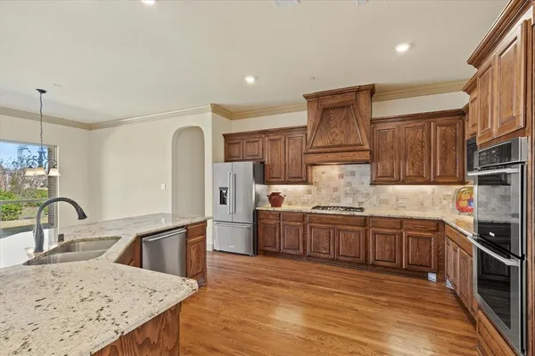a kitchen with stainless steel appliances granite countertop a sink stove and refrigerator
