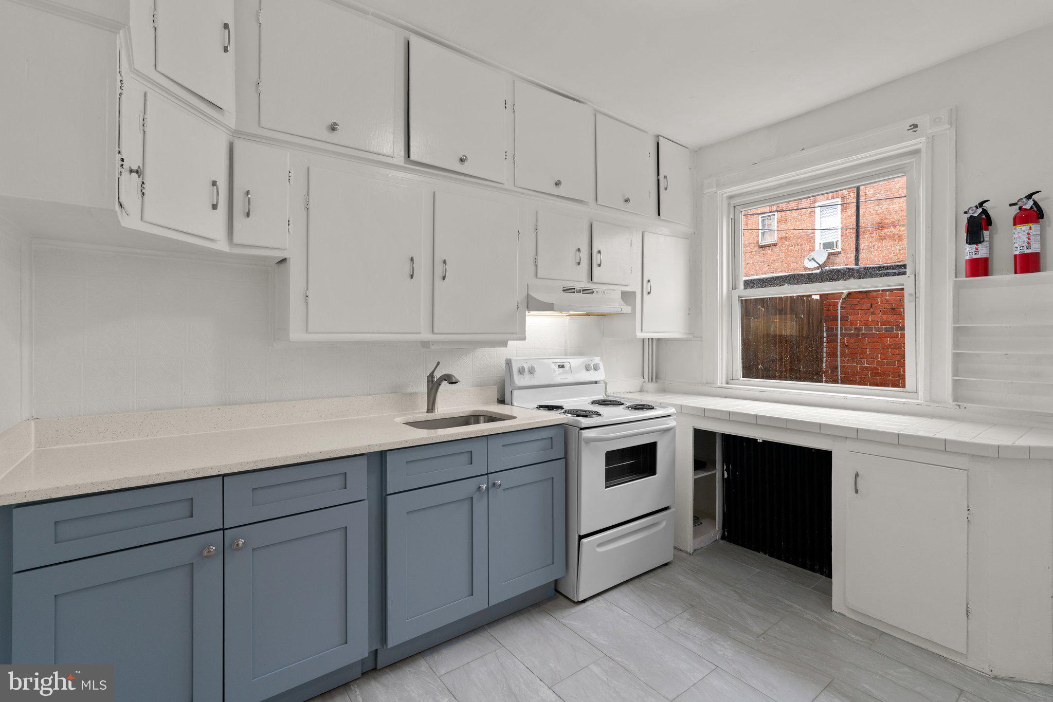 4208 Sheldon Avenue Baltimore, MD 21206 - Photo 10 of 26 a kitchen with granite countertop white cabinets and white appliances