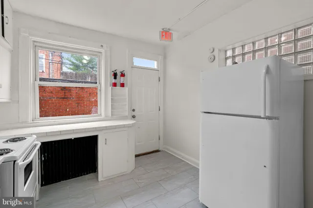a kitchen with granite countertop white cabinets and white appliances