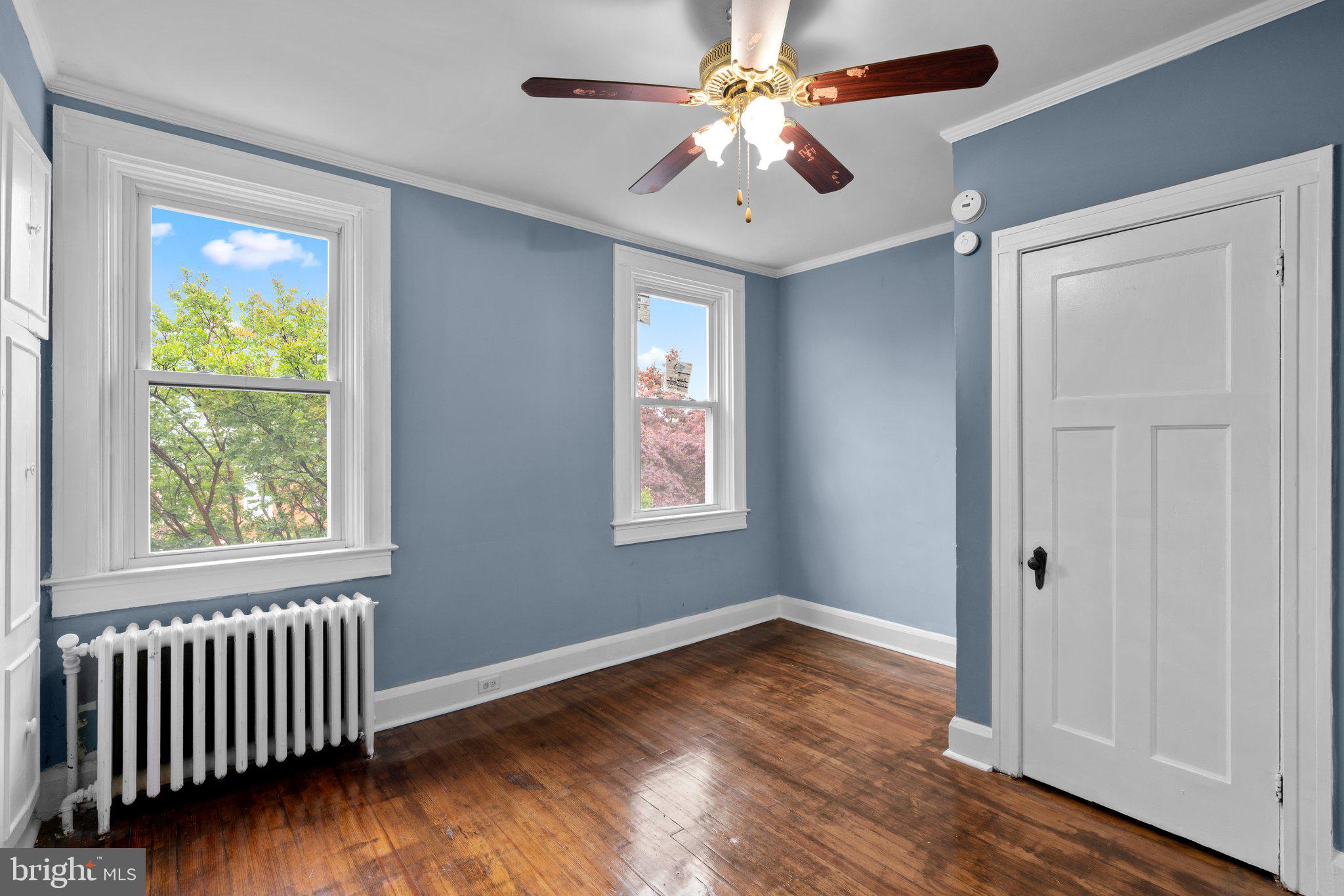 4208 Sheldon Avenue Baltimore, MD 21206 - Photo 12 of 26 an empty room with wooden floor chandelier fan and windows