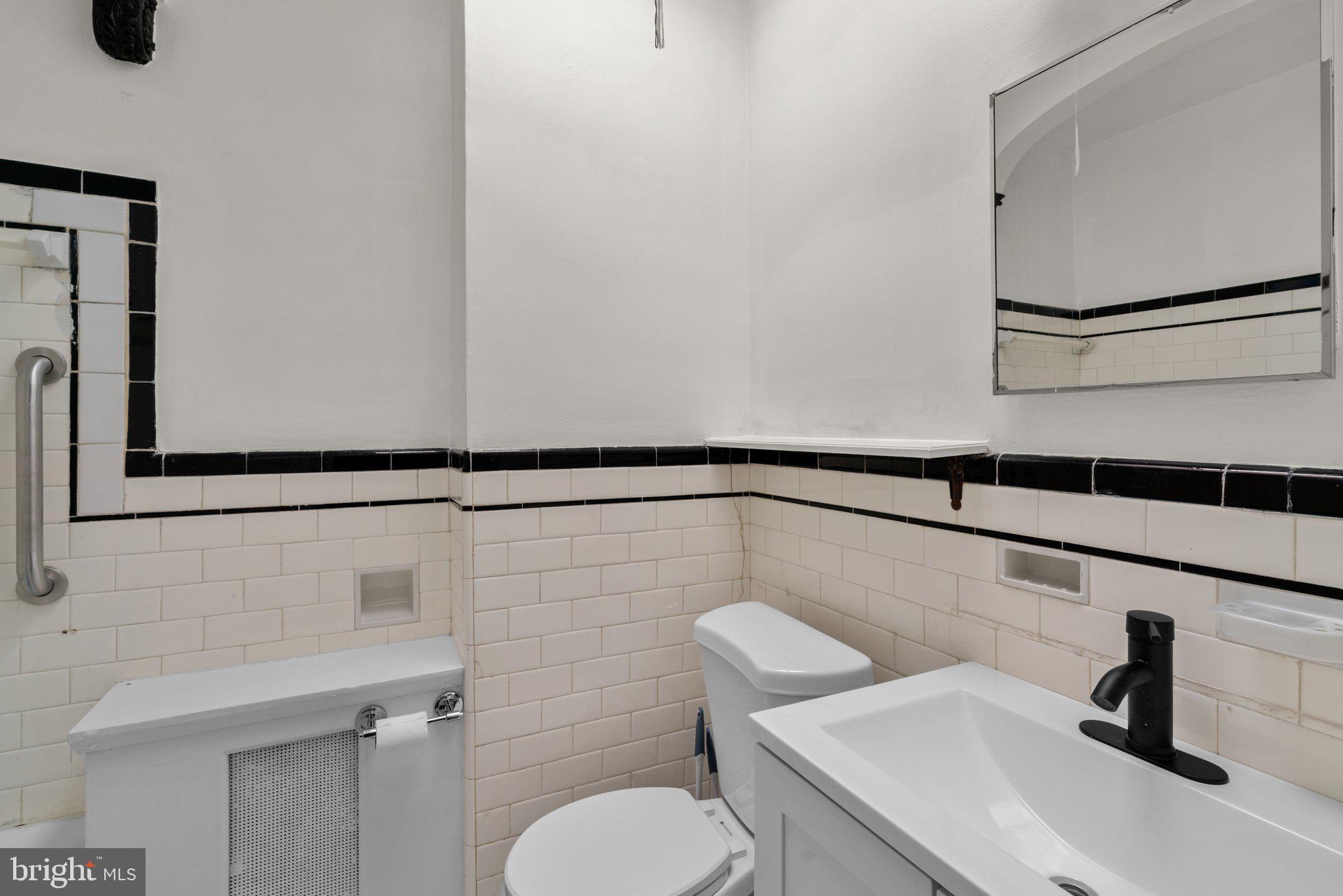 4208 Sheldon Avenue Baltimore, MD 21206 - Photo 13 of 26 a bathroom with a sink a toilet and a mirror