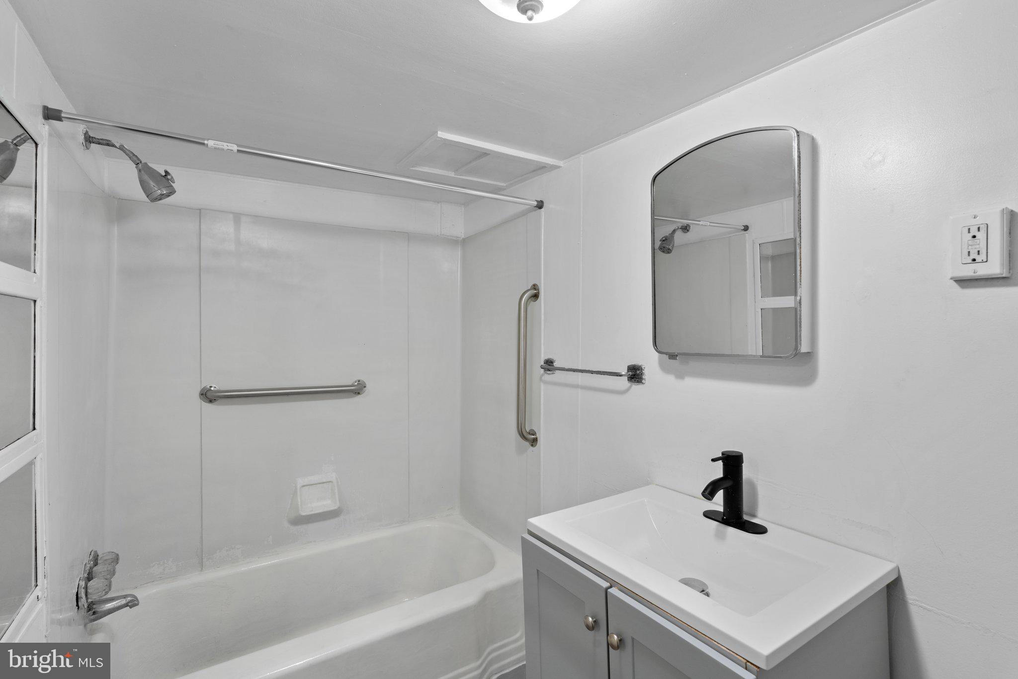 4208 Sheldon Avenue Baltimore, MD 21206 - Photo 19 of 26 a bathroom with a sink a mirror and a bathtub