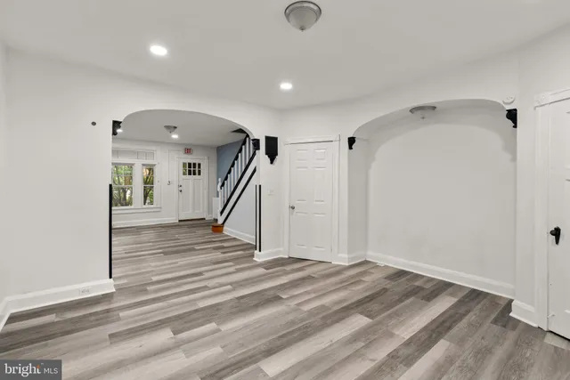 a view of a hallway with wooden floor and windows