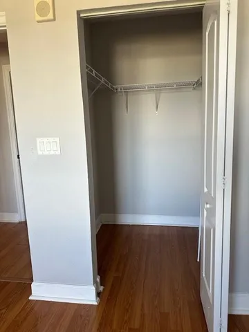 a view of walk in closet with wooden floor