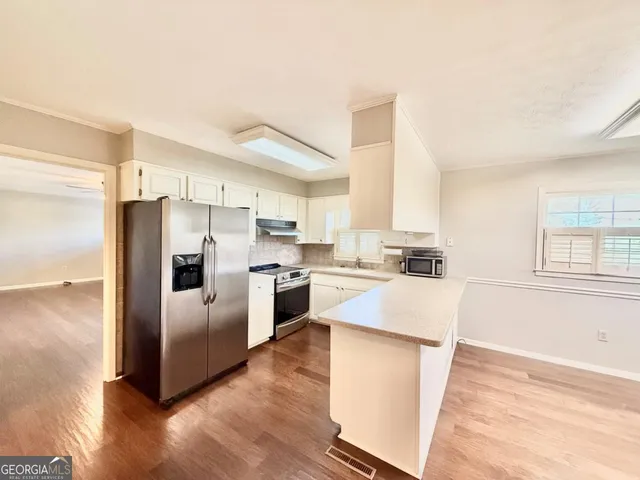 a kitchen with a refrigerator sink and cabinets