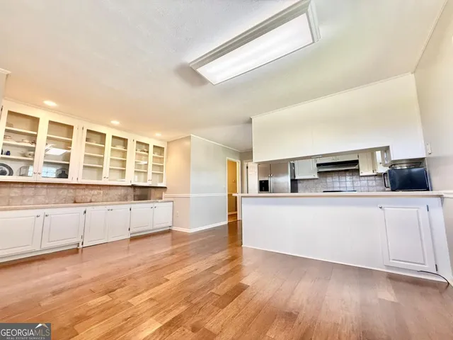 a view of a kitchen with wooden floor and electronic appliances